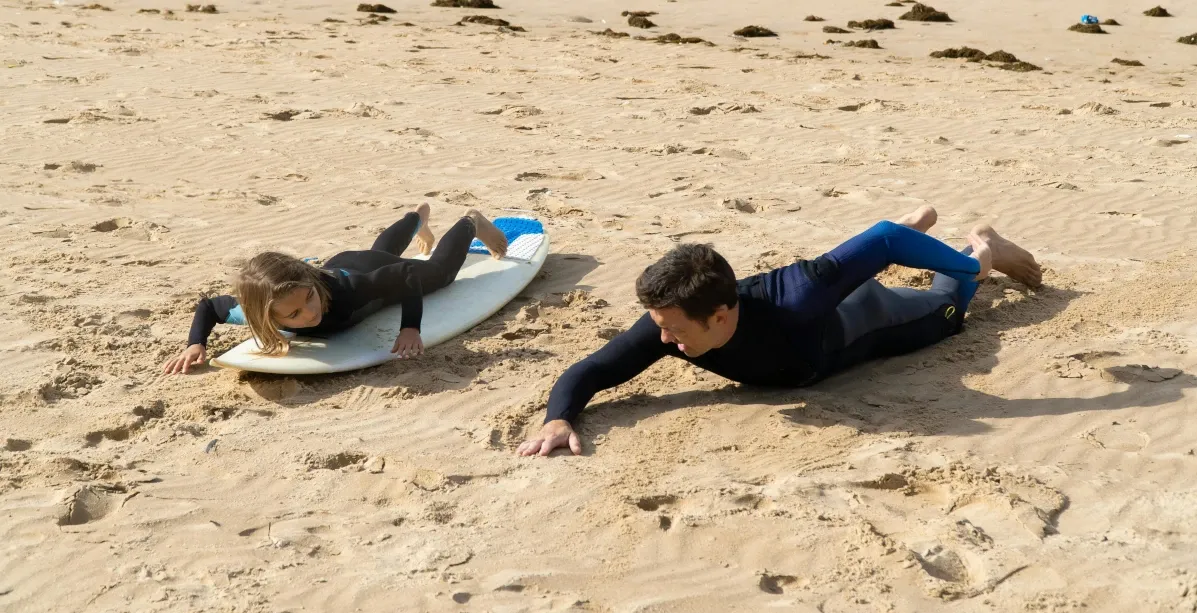 Zwei Surfer am Strand in einem Surf-Coaching bei Trockenübung